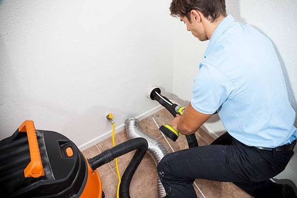 Man cleaning dryer vent in home.